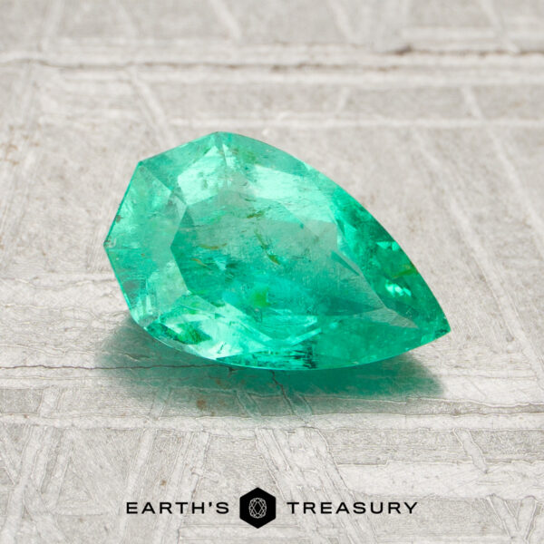 1.08-Carat Colombia Emerald (Oiled) A faceted, pear-shaped 1.08-carat Colombia emerald (oiled) rests on a textured light surface with the "Earth's Treasury" logo and text below.