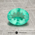 A 1.17-carat Colombia emerald (oiled), oval-cut and green, rests on a textured gray surface with the Earth's Treasury logo below.