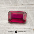 A 1.13-carat, emerald-cut ruby rests on a textured surface with "EARTH'S TREASURY" and a hexagonal logo below.