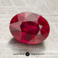 A 2.51-carat faceted oval ruby rests on a textured surface, with "EARTH'S TREASURY" and a hexagonal logo displayed at the bottom.