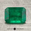 A 2.02-carat emerald gemstone with a rectangular, faceted cut rests on a textured surface, displaying the words "Earth's Treasury" below.