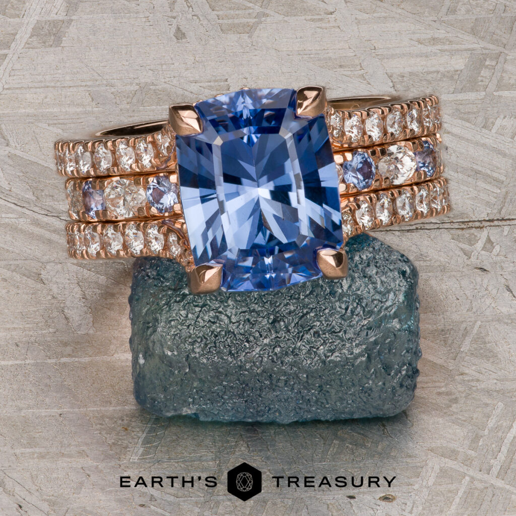 The "Larson, David [custom gallery]" features a cushion-cut blue gemstone ring with diamond accents on a rose gold band, displayed on rough blue stone with the Earth's Treasury logo below.