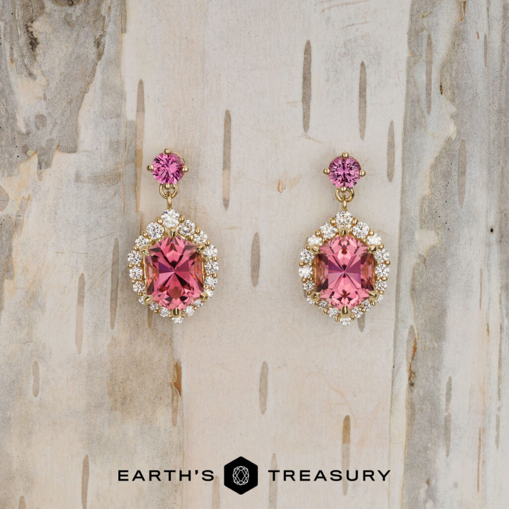 Pintea, Victor [custom gallery]: Gold earrings featuring oval pink gemstones encircled by small clear stones, shown on a light wood background with the Earth's Treasury logo below.