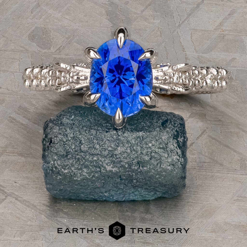 The Lettiere, Jacob [custom gallery] features a silver ring with an oval blue gemstone displayed on a rough blue crystal, with "Earth's Treasury" below.