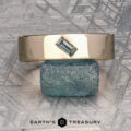 A gold ring featuring a rectangular green gemstone from our ET Stock collection in 14K Yellow Gold is shown balanced atop a rough blue-green stone, with the Earth’s Treasury logo and text below. Ready to Ship.