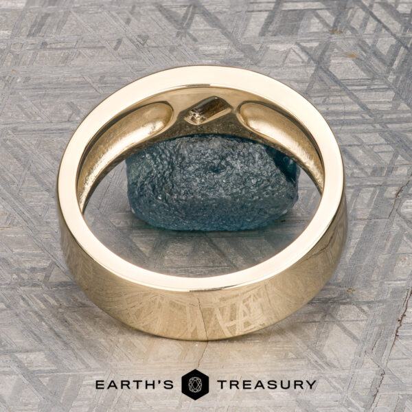 The "Eiger" Ring Introducing the ET Stock ring: a stunning piece in 14K yellow gold, featuring a brilliant blue gemstone at its center. Displayed upright on a textured gray surface with the “Earth’s Treasury” logo beneath, this exquisite ET Stock ring is ready to ship.