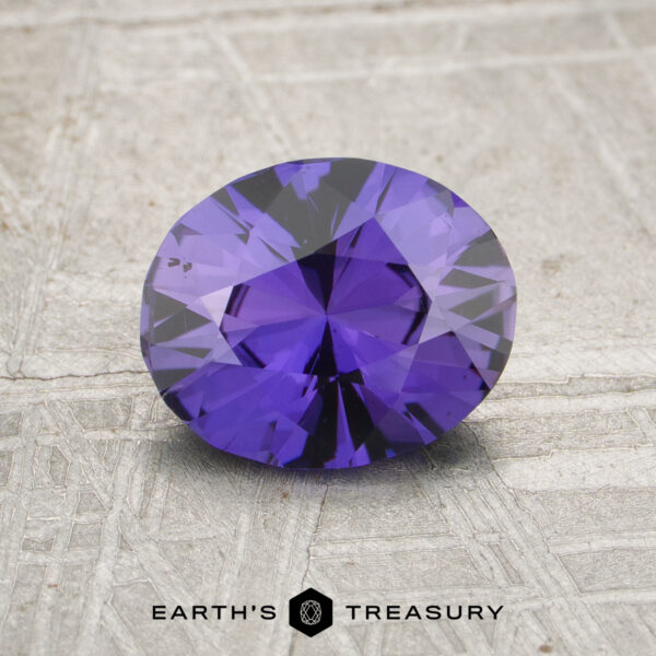 1.46-Carat Deep Purple Ceylon Sapphire (Unheated) A 1.46-carat unheated Ceylon sapphire with an oval cut is displayed on a textured gray surface, featuring the "Earth's Treasury" logo below.