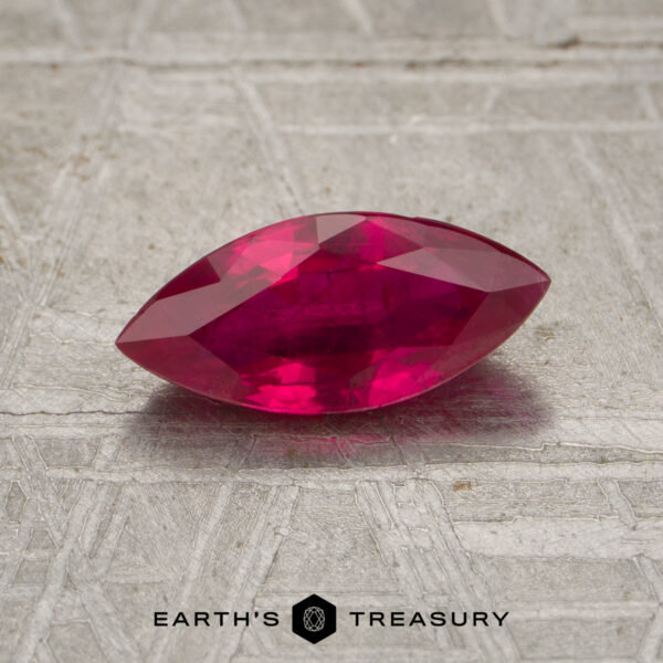 0.96-Carat Madagascar Ruby (Heated) A 0.96-carat marquise-cut ruby is displayed on a textured metallic surface with the text "EARTH'S TREASURY" at the bottom.