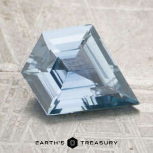 A 2.36-carat blue sapphire with a step-cut design is displayed on a textured surface, featuring the "Earth's Treasury" logo and text at the bottom.