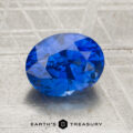 A 2.19-carat heated oval-cut blue sapphire with brilliant facets rests on a metallic surface; the "Earth's Treasury" logo and text appear at the bottom of the image.