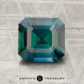A 2.11-carat heated sapphire with an emerald cut is shown on a textured gray surface, with "EARTH'S TREASURY" at the bottom.