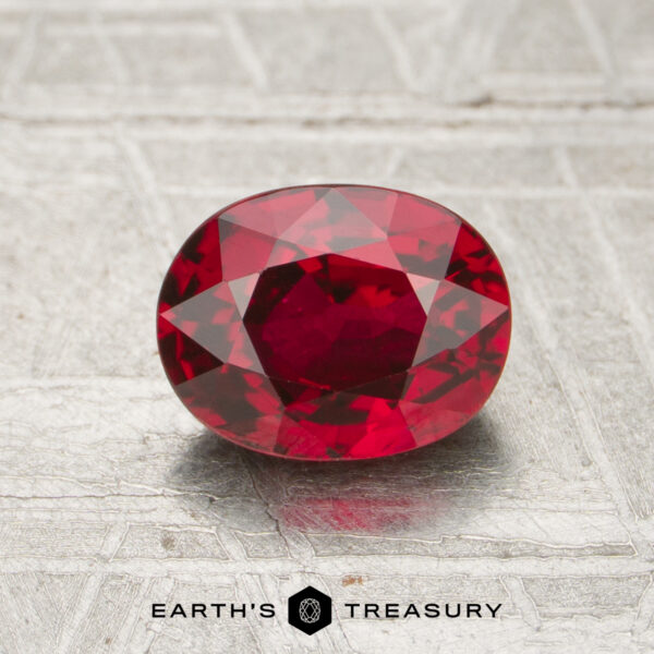 1.30-Carat Ruby A 1.30-carat oval-cut ruby is displayed on a textured metallic surface, with the "Earth's Treasury" logo beneath it.