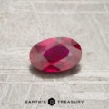 A 0.50-carat faceted ruby in an oval shape is displayed on a textured gray background with the "Earth's Treasury" logo at the bottom.