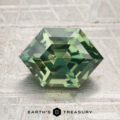 A 2.38-carat heated sapphire, cut in a green hexagonal shape with step facets, rests on a textured surface. The "EARTH'S TREASURY" logo and text appear at the bottom.
