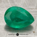 A 4.39-carat emerald, pear-shaped and faceted, rests on a textured metallic surface. "EARTH'S TREASURY" appears at the bottom of the image.