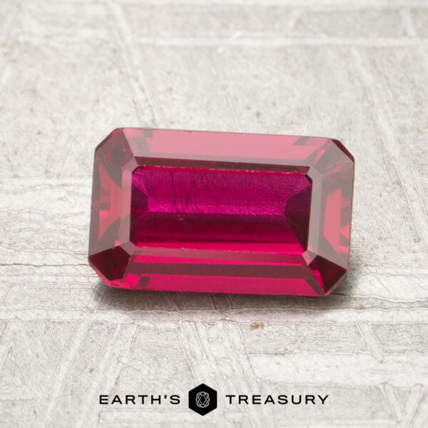 1.13-Carat Ruby A 1.13-carat faceted ruby is shown on a textured surface with the "Earth’s Treasury" logo beneath it.