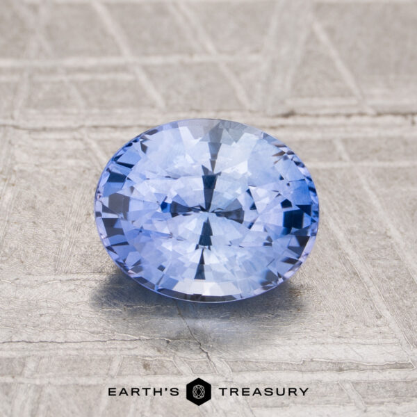 1.68-Carat Ceylon Sapphire (Heated) A 1.68-carat heated Ceylon sapphire, faceted in an oval shape, is shown on a textured light gray surface with "EARTH'S TREASURY" displayed at the bottom.
