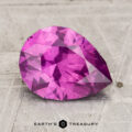 A 2.43-carat pastel pyrope garnet, faceted and vibrant pink, is displayed on a textured, light-colored surface with the text "Earth's Treasury" below.