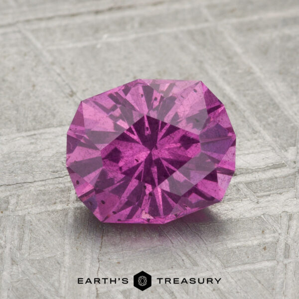 1.91-Carat Pastel Pyrope Garnet A 1.91-carat pastel pyrope garnet, round-cut and faceted, is shown on a textured gray background with "EARTH'S TREASURY" displayed at the bottom.