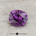 A 1.21-carat color-change garnet with a geometric cut rests on a textured light gray surface; the "Earth's Treasury" logo appears at the bottom.