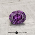 A 0.81-carat color-change garnet gemstone is displayed on a textured, light-colored surface with the text "Earth's Treasury" below it.