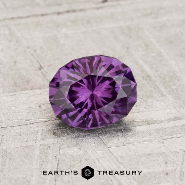0.81-Carat Color-Change Garnet A 0.81-carat color-change garnet gemstone is displayed on a textured, light-colored surface with the text "Earth's Treasury" below it.