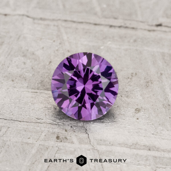 0.55-Carat Color-Change Garnet A 0.55-carat color-change garnet, round-cut, displayed on a textured light surface with "Earth's Treasury" at the bottom.