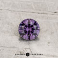 0.40-carat color-change garnet, round brilliant-cut, displayed on a textured light gray surface with "Earth's Treasury" text at the bottom.