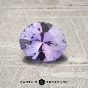 A 1.10-carat unheated Purple Ceylon Sapphire, round-cut, is showcased on a textured light surface with "EARTH'S TREASURY" at the bottom.