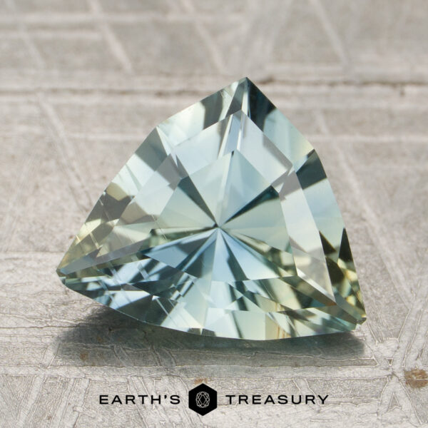 2.15-Carat Aqua-Yellow Particolored Malawi Sapphire (Unheated) A 2.15-carat unheated aqua-yellow particolored Malawi sapphire is displayed on a textured surface above the Earth's Treasury logo.