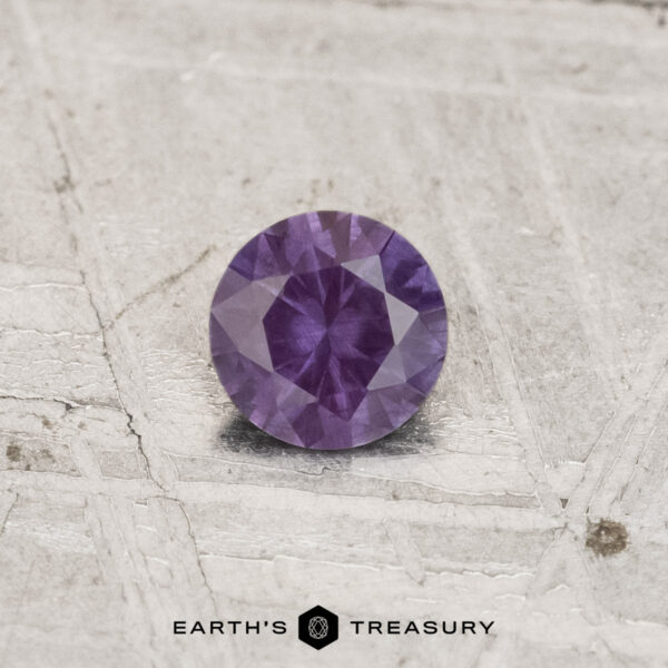 0.29-Carat Color-Change Garnet A 0.29-carat color-change garnet with a round cut is shown on a textured, light surface, with "EARTH'S TREASURY" displayed below.