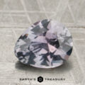 A 2.38-carat purplish gray to lilac pink Montana sapphire (unheated) rests on a textured surface, with "EARTH'S TREASURY" and logo shown at the bottom.