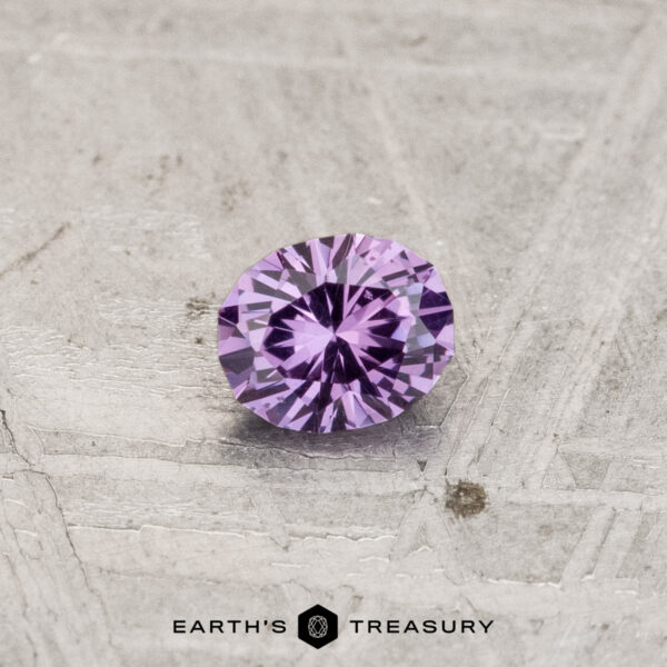 0.28-Carat Color-Change Garnet A 0.28-carat color-change garnet, round brilliant-cut, sits on a textured light gray surface with the "Earth's Treasury" logo below.