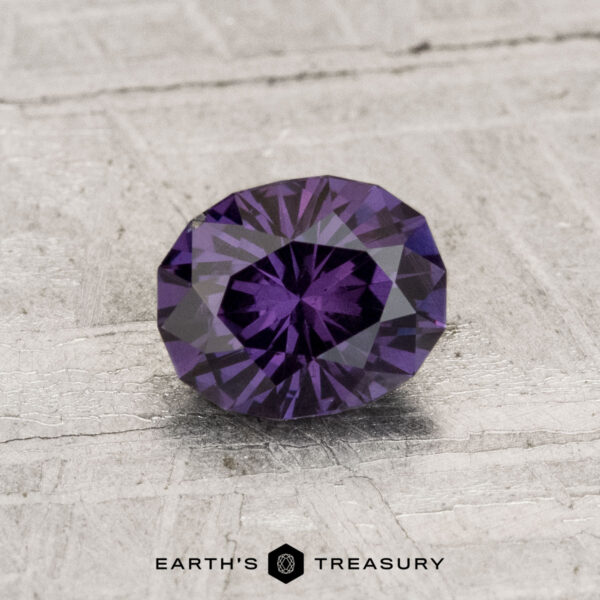 0.96-Carat Color-Change Garnet A 0.96-carat color-change garnet, faceted in an oval cut, is displayed on a textured light gray surface with "Earth's Treasury" at the bottom.