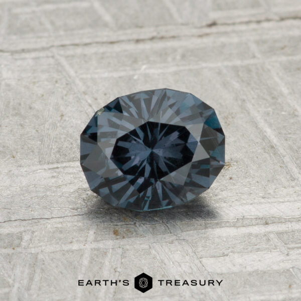 0.96-Carat Color-Change Garnet A 0.96-carat color-change garnet, round and faceted, is displayed on a gray textured surface with "EARTH'S TREASURY" at the bottom.
