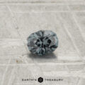 A 0.30-carat Color-Change Garnet is showcased on a textured gray surface with "EARTH'S TREASURY" displayed at the bottom.