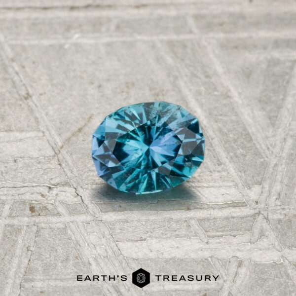 0.33-Carat Kornerupine A 0.33-carat Kornerupine gemstone rests on a textured, geometric-patterned surface with "EARTH'S TREASURY" at the bottom.