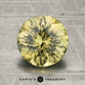 A 2.29-carat unheated greenish-yellow Kenya sapphire, round and faceted, is displayed upright on a gray patterned surface with the "Earth's Treasury" text and logo below it.