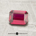 A 1.16-carat, rectangular emerald-cut ruby is displayed on a light, textured surface with the "Earth's Treasury" logo at the bottom.