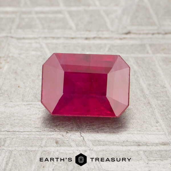 1.16-Carat Ruby A faceted 1.16-carat rectangular ruby is displayed on a textured surface with "Earth's Treasury" written below.