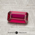 A 1.30-carat ruby, rectangular and faceted, is displayed on a textured gray surface. The text "EARTH'S TREASURY" appears at the bottom of the image.