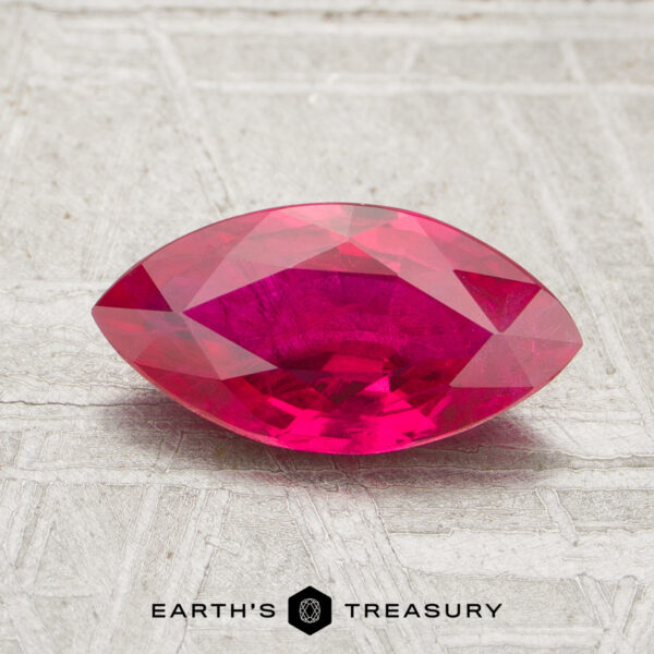 1.22-Carat Ruby A 1.22-carat marquise-cut deep pink ruby is displayed on a textured surface with the words "Earth's Treasury" beneath it.