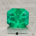 A 2.12-carat rich green Colombian emerald (oiled), cut in a rectangular faceted shape, displayed on a textured surface with the text "Earth's Treasury" below.