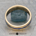 A "Stacked from 55 images. Method=B (R=14,S=2)" gold ring with a blue inlay is displayed upright around a rough blue stone on a textured gray surface, with the "Earth's Treasury" logo and name at the bottom.