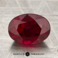 A 4.05-carat deep red Mozambique ruby (heated), cut in a faceted oval, displayed on a textured surface with the "EARTH'S TREASURY" logo and text below.