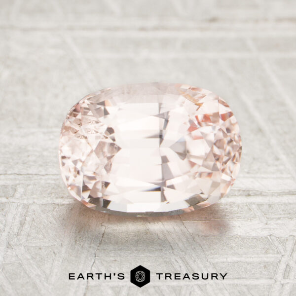 2.24-Carat Ceylon Sapphire A faceted, oval-cut pale pink 2.24-Carat Ceylon Sapphire is displayed on a light textured surface with the Earth’s Treasury logo below.