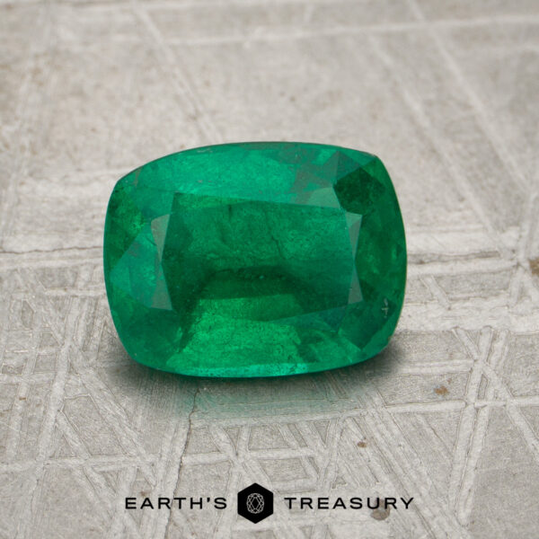 2.05-Carat Rich Green Zambian Emerald A 2.05-carat rich green Zambian emerald is displayed on a textured, patterned surface with the text "Earth's Treasury" below it.