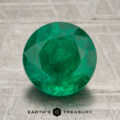 A 2.34-carat rich green Zambian emerald, expertly round-cut, is displayed on a textured gray surface with the "Earth's Treasury" logo and text beneath it.