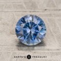 1.49-carat teal blue to violet color-change Montana sapphire gemstone shown on a textured surface, with the "Earth's Treasury" logo and text beneath.