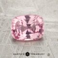 A cushion-cut pink gemstone, product JM-001-398JM-G, rests on a textured gray surface with the "Earth's Treasury" logo below.